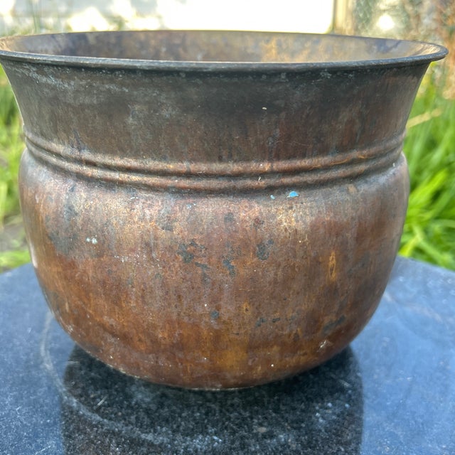 This antique brass planter/cachepot features a natural patina, adding to its rustic charm. Handmade from brass, it exudes...