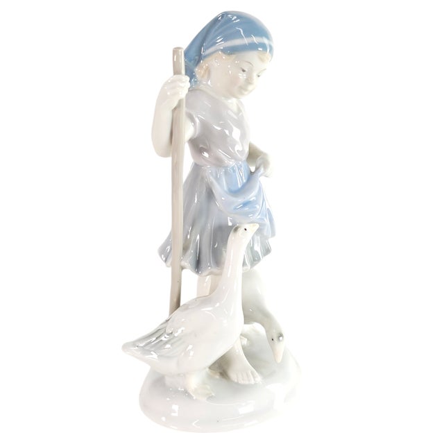 The girl stood small but steady, her hands firm, her face calm. The geese followed, their necks stretched long, eyes...