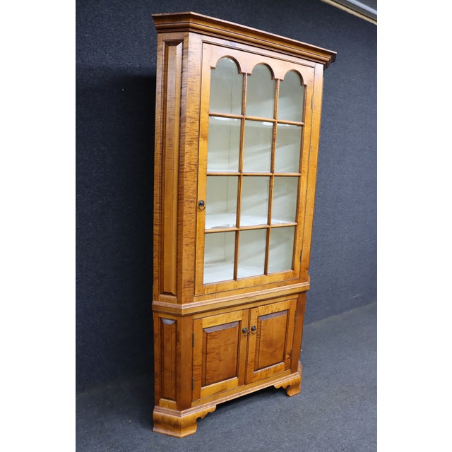 D.R. Dimes Benchmark tiger maple corner cabinet featuring beautifully figured curly maple veneers and a classic, timeless...