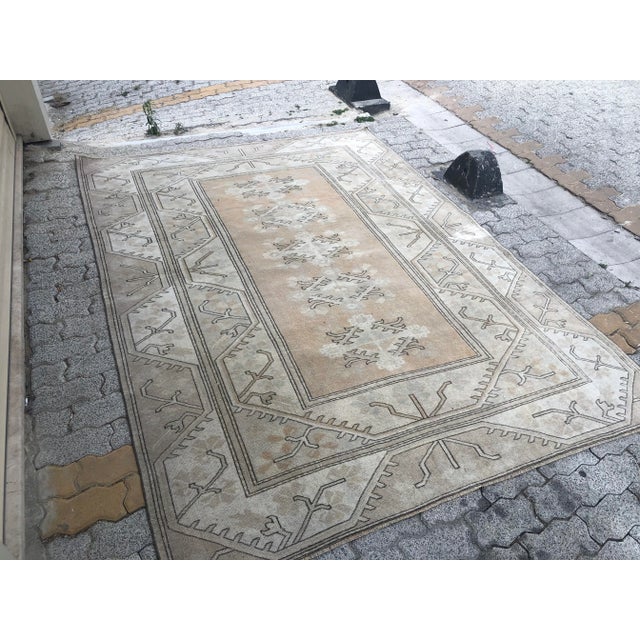 This is a vintage Turkish Oushak rug from the 1960s. The piece was hand-knotted.