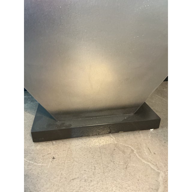 Striking stainless steel console table with a bold, sculptural silhouette defined by its sweeping concave top and angular...