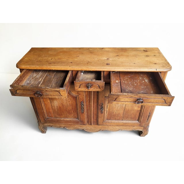 A low Louis XV style provincial buffet, France, 19th century, opening with three drawers in a frieze and two doors in the...