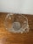 Vintage clear pressed glass serving bowl featuring decorative double handles, etched accents, and a geometric pressed-...
