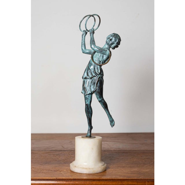 This elegant early 20th-century French statuette captures the grace and charm of a female figure engaged in a lively...