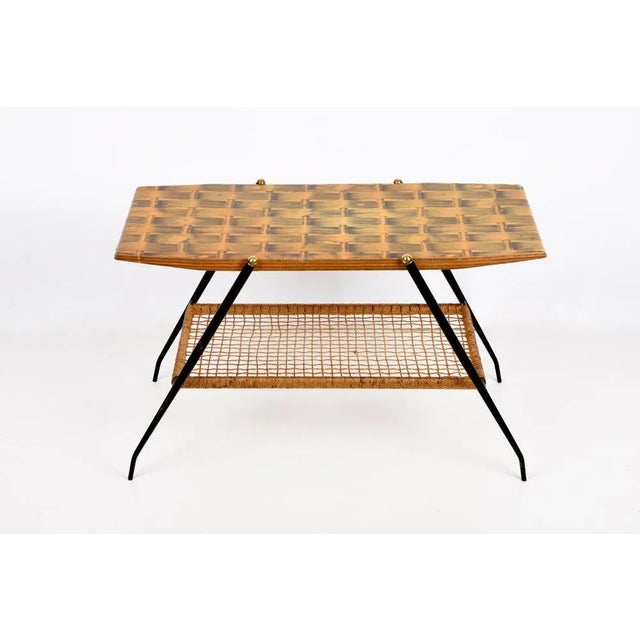Marvellous mid-century coffee table in wood, brass and black metal. This table was produced in Italy during the 1950s. It...