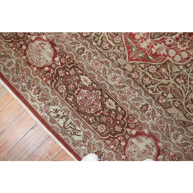An oversize Antique Persian Tabriz rug woven early 20th century with cinnamon colored ground and soft brown medallion. The...