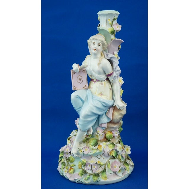 Item : A magnificent hard-paste porcelain candlestick featuring a central woman, depicting the muse of poetry, embellished...