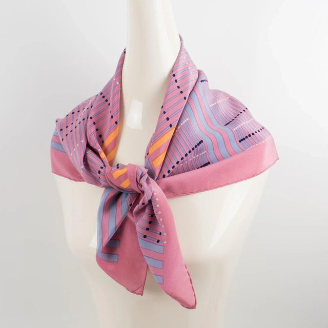 This lovely silk scarf by Christian Dior Paris features a geometric design print in pink and orange colors. The Christian...