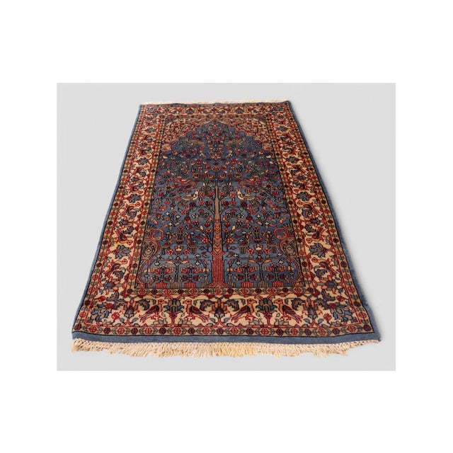 Elegant and evocative, this vintage rug features a rich "Tree of Life" motif—symbolizing eternity and the connection...