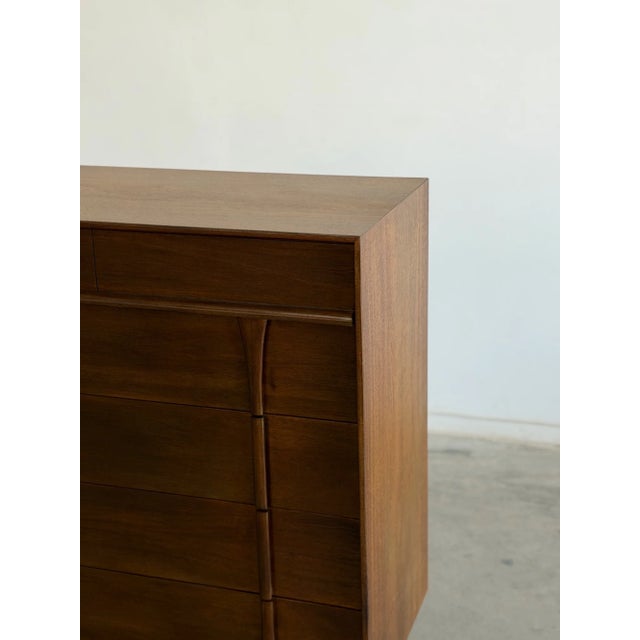 W42 D20 H47 This restored mid century dresser, defined by its sculptural vertical pulls that seamlessly integrate into the...