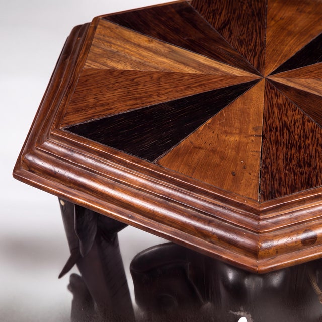 This is an early 20th century Anglo-Indian carved elephant form drinks table with sunburst parquetry top. There are three...