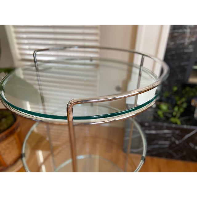 This compact, chrome serving cart has an elegant, Minimalist style. The slender, tubular chrome forms a skeletal framework...
