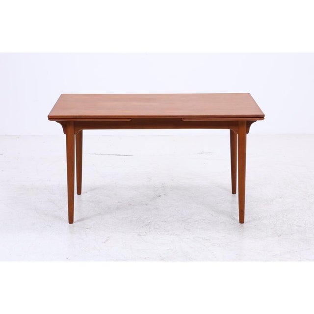 The classic Model 54 dining table by Omann Jun features a beautiful teak grain and the characteristic curved details on...