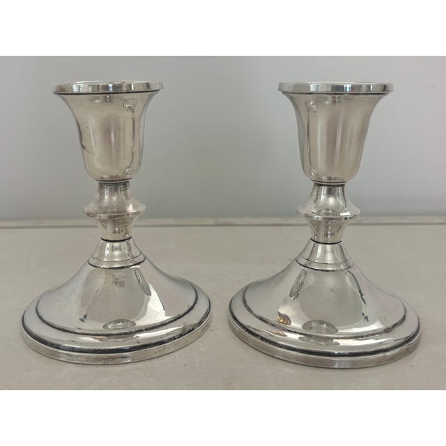 Matching weighted sterling silver pair of Edwardian candlestick holders, with fluted baluster column on a circular base....
