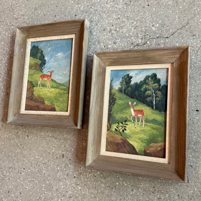 Pair of sweet and petite folk art acrylic paintings depicting natural landscapes centering on deer and fawn. The paintings...
