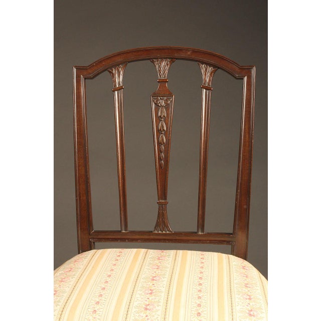 Elegant pair of late 19th-century English Hepplewhite style side chairs, crafted in mahogany and distinguished by fine,...