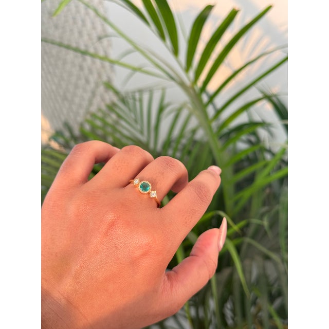 This Trilogy ring features a 0.46 carat round cut natural emerald set in 14k yellow gold. The center stone measures...