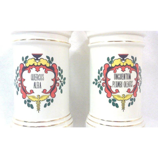 A pair of apothecary style table lamps in off white ceramic with Rod of Asclepius design on the front of each lamp. These...