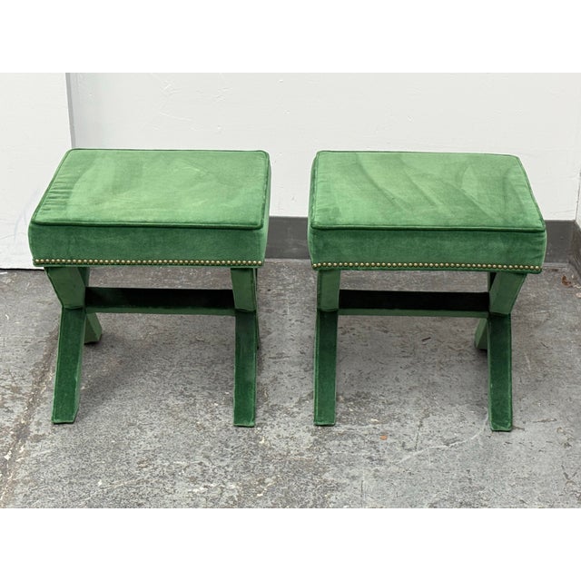 Design Plus Gallery presents a Pair of Hollywood Regency Style Green Velvet X-Base Ottoman Stools. The pair has square...