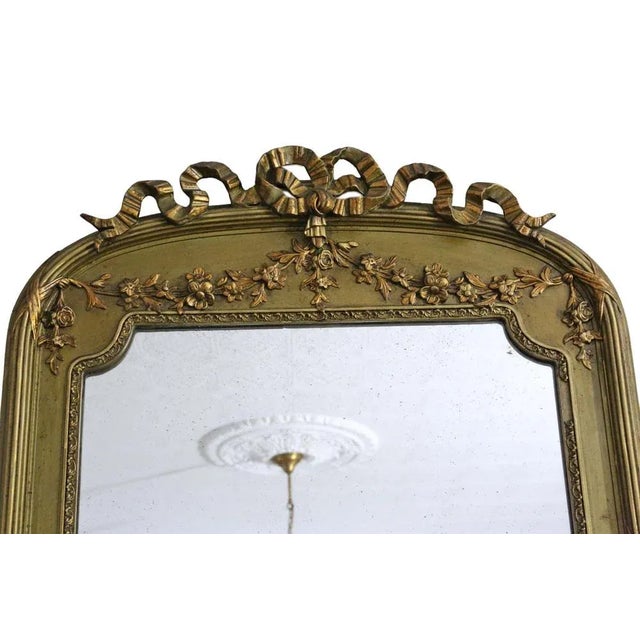 Antique large gilt overmantle wall mirror, crafted around 1900, boasting fine quality with ribbon and floral decoration....