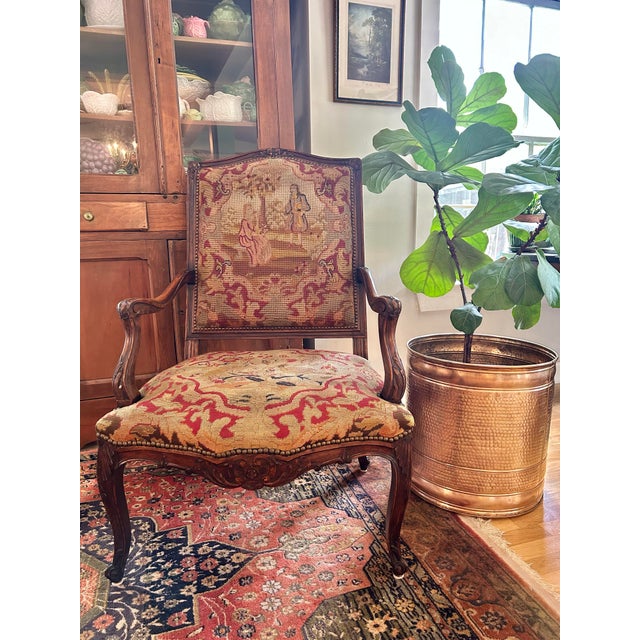 Most likely hand carved in the 1870’s-1880’s this generous throne armchair bears its original needlepoint and petit point...