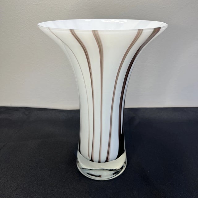 The warm chocolate tones contrast beautifully with the creamy white glass, allowing the vase to complement a variety of...