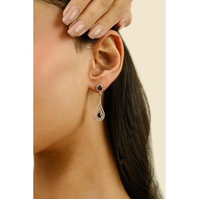 These vintage-inspired dangle earrings feature 4 pear cut blue sapphire totaling 1.15 carats, set in rich 18k yellow gold....