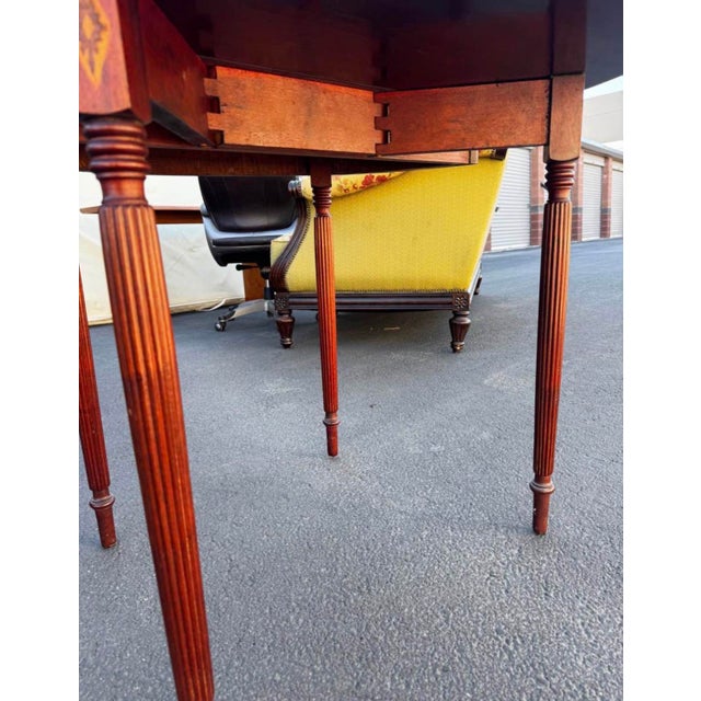 Elegant Sheraton-style flip-top game table featuring a half-moon silhouette, decorative urn and diamond inlay, contrasting...