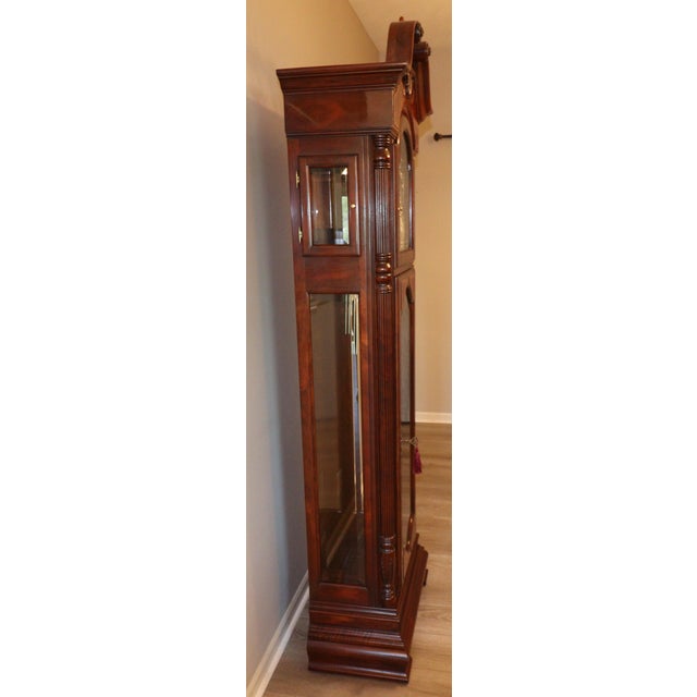 An exceptional Howard Miller Presidential Collection grandfather clock featuring an ornate swan-neck bonnet, richly...