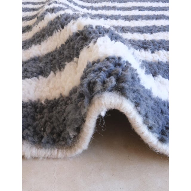 This Modern Striped Moroccan Rug, crafted by Morocco’s Boujad tribe, features elegant stripe patterns paired with a...