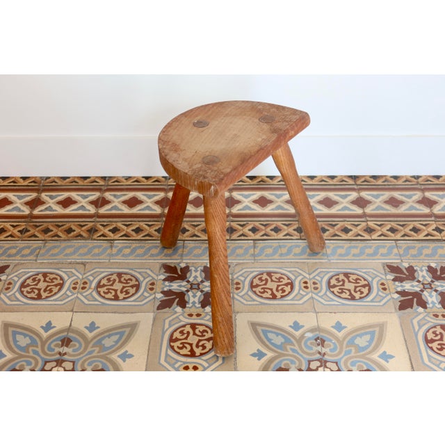 Solid wood tripod stool with a half-moon seat, featuring a simple and authentic design typical of antique rustic...