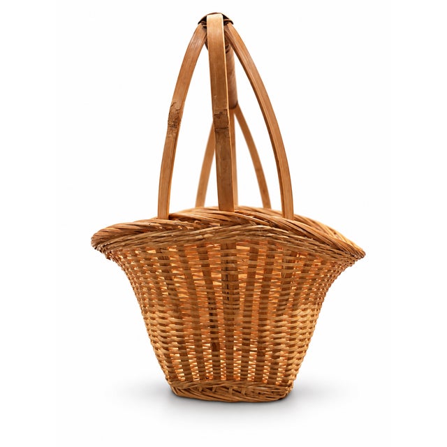 A charming vintage wicker gathering basket with a warm honey color, a gently shaped rim, and a tall handle finished with...