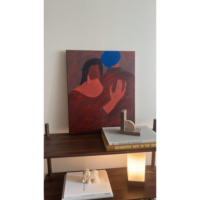This contemporary figurative painting explores the understated beauty of human connection. Through simplified forms and a...
