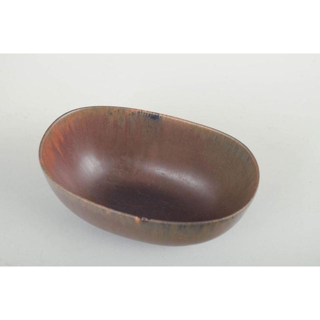 Carl-Harry Stålhane for Rörstrand. Bowl, mid-20th century. Oval stoneware bowl with low foot and reddish-brown glaze with...