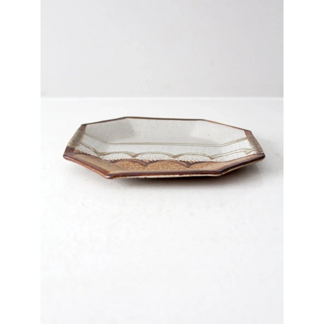 This vintage octagonal studio pottery dish by ceramicist Lauren Sargent is dated 1982. It features a dynamic hand-painted...