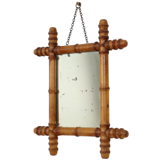 Antique faux bamboo mirror featuring its original foxed mirror plate and executed entirely in the Chinoiserie style—a...