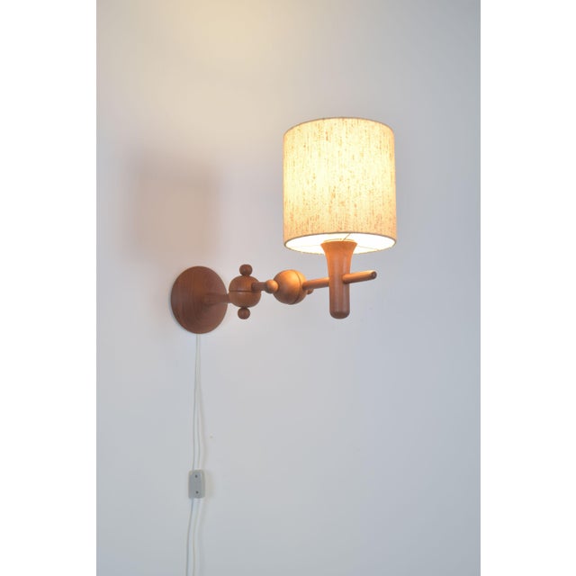 Danish wall lamp from the 1960s made of teak and with a sculptural design. This lamp is adjustable in various ways. The...