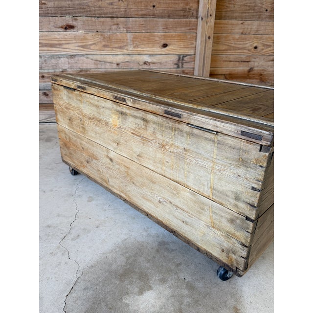 A gorgeous antique wooden trunk featuring hand-cut dovetail joinery, wide plank construction, and its original rolling...