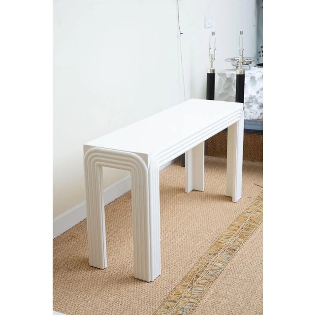 This vintage white lacquered over wood rectangle console or sofa table has been newly restored and re painted in white. It...