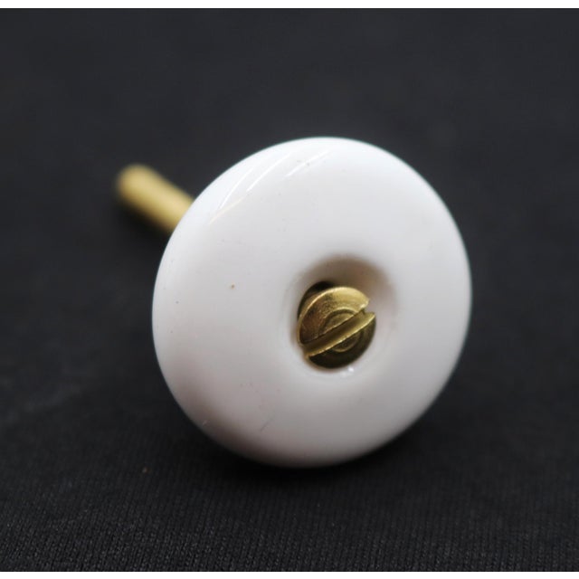 Vintage cabinet or drawer knob made of white ceramic with a round shape. A mounting screw is included. Good condition with...