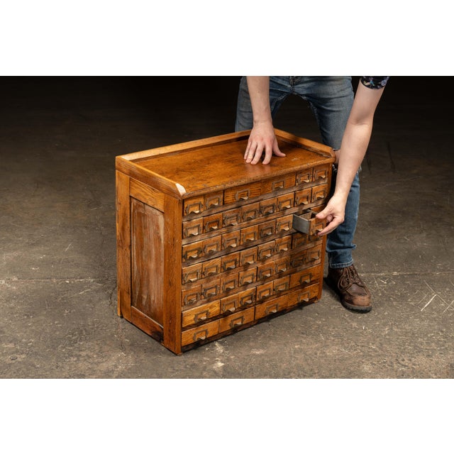 Antique oak hardware cabinet. Classic multi-drawer apothecary cabinet featuring solid oak construction with rich medium-...