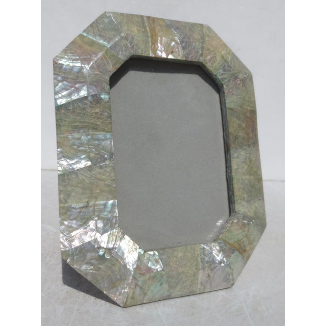 Abalone Shell photo frame. Octagonal-shaped frame with glass face and grey velvet back stand. Shell is treated with amber...