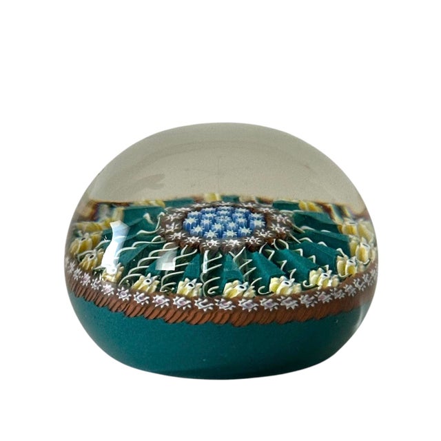 A gorgeous, vintage art glass paperweight. Features an open “wagon wheel” style design with 15 ribbon twists radiating...