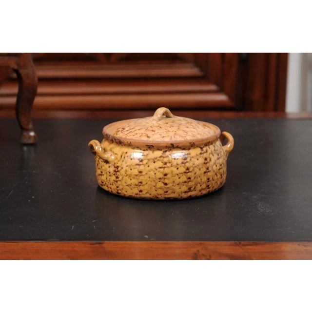 A French pottery covered baking dish from the 19th century, with brown glaze and lateral handles. Created in France during...