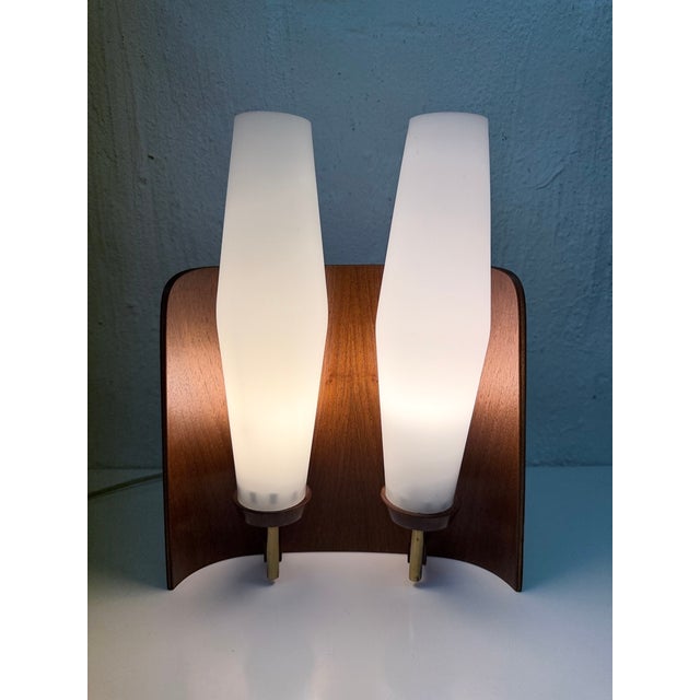 One 1960s wall lamp, two-light, E14 socket. White glass, teak. Good used condition. Minor wear. Patina. Small chips on the...