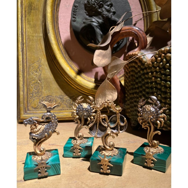 A refined set of four Italian mid-century zodiac place card holders executed in gilt 800 silver and raised on polished...