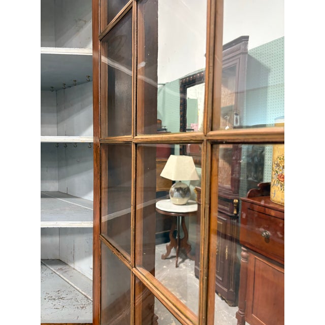 This is a mid 19th century handcrafted walnut corner cupboard. This handsome corner cabinet features it’s original...