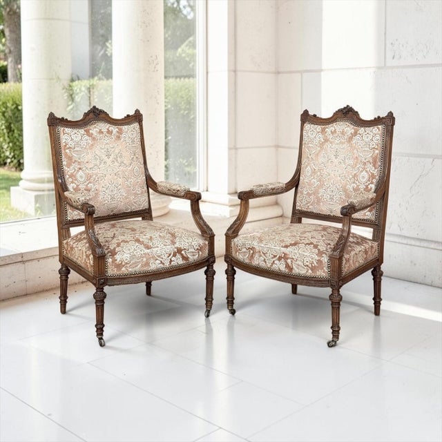 A pair of 19th century French Louis XVI armchairs, crafted of solid French walnut, carry the grace of the neoclassical age...