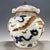 An impressive Chinese porcelain covered jar with a distinctive lotus-leaf shaped lid. The white-glazed body is decorated...