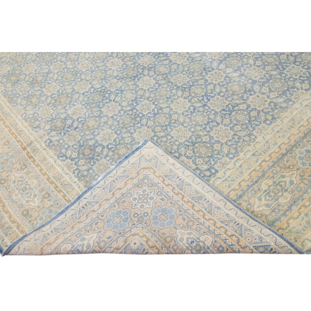 Beautiful antique Persian Tabriz hand-knotted wool rug with a blue field. This piece has a beige frame and accent in an...
